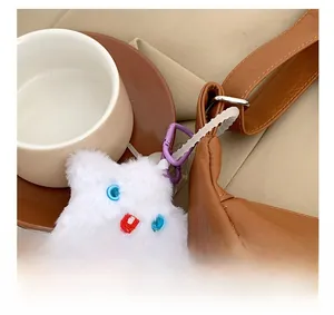 Detail of white plush star charm with purple hook on brown pebble leather tote bag