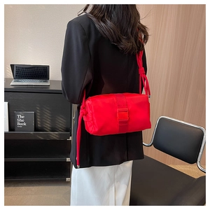 Detail of red nylon crossbody bag with buckle closure and unique thick rope strap design