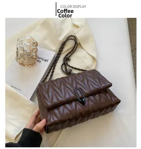 Detail of coffee brown quilted crossbody bag with stylish chain strap and metal lock
