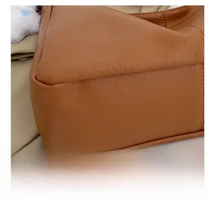 Detail of precise stitching and pebble leather texture on a brown tote bag