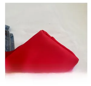 Detail view of red nylon crossbody bag with visible fabric texture and quality stitching