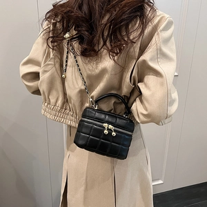 Chic black quilted bucket bag with gold chain strap shown on model for autumn winter