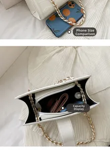 Detail showing white crocodile pattern chain bag capacity with phone for scale
