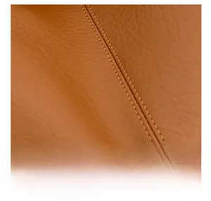 Detailed macro view of premium brown lychee texture leather with double stitching detail
