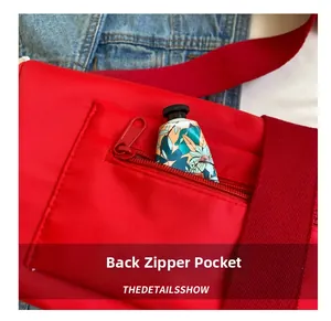 Detail of red nylon crossbody bag with back zipper pocket holding floral hand cream