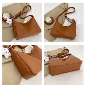 Detail view of brown faux leather tote with adjustable strap and star plush pendant