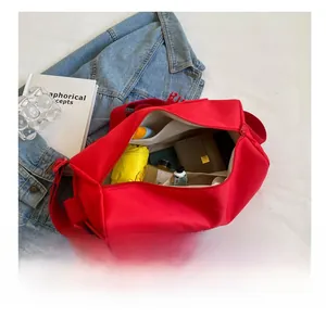 Detailed interior of red nylon crossbody bag showing large storage capacity and compartments