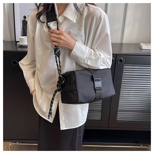 Detail of black nylon crossbody bag with unique black and white rope knot shoulder strap