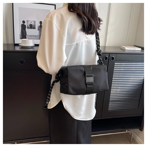 Detail of black nylon crossbody bag with chunky black and white rope shoulder strap knot