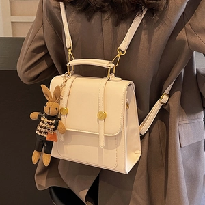 White vintage faux leather square backpack with golden buckle and rabbit pendant detail