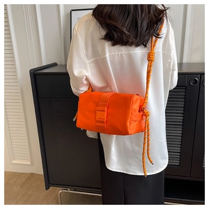 Bright orange nylon crossbody bag with woven rope strap shown on female model back