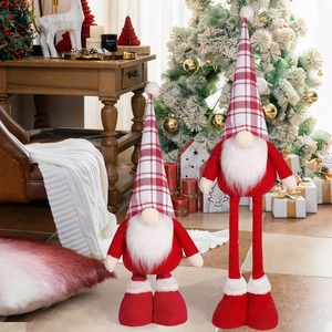 Detail of Christmas gnomes with red plaid hats standing near a decorated holiday tree