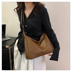 Close-up of brown pebbled leather hobo bag showing texture and stitching details