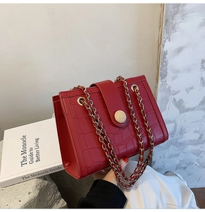 Detail of red crocodile pattern bridal handbag with chain strap and retro clasp