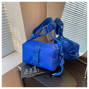 Detail of Klein blue nylon crossbody bag featuring stylish rope knot strap and buckle