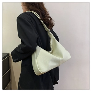 Detail of light green hobo bag with litchi grain leather and adjustable shoulder strap