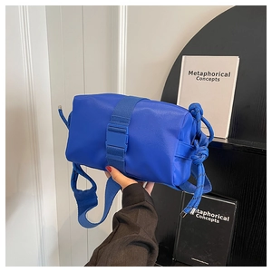 Detail of Klein Blue nylon crossbody bag showing buckle strap and rope shoulder strap