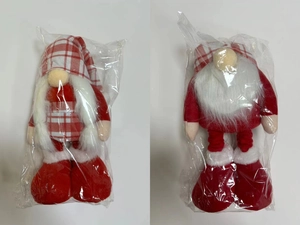 Detail of a standing Christmas gnome doll with a red plaid hat and white beard in packaging
