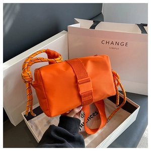 Detail of orange nylon crossbody bag featuring heavy rope strap and secure plastic buckle