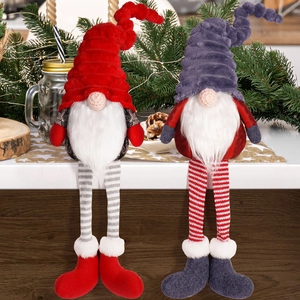 Detail of red and grey Christmas gnomes with long striped legs in a cozy winter setting