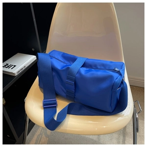Macro detail of the durable electric blue nylon fabric and adjustable strap on the crossbody bag
