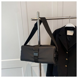Detail of black nylon crossbody bag with adjustable buckle strap and wide webbing