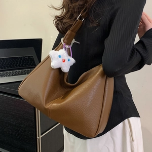 Brown lychee leather tote bag with plush star charm and adjustable strap for women