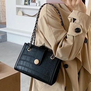 Elegant black crocodile pattern crossbody bag with chain strap and gold buckle