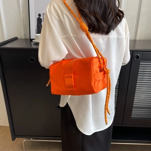 Vibrant orange nylon crossbody bag with woven rope strap and plastic buckle detail