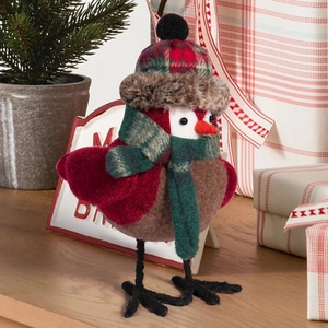 Close-up of bird ornament with plaid hat and faux fur trim on wooden surface