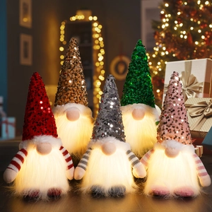 Détail de cinq gnomes de Noël à paillettes avec des barbes lumineuses à LED chaudes