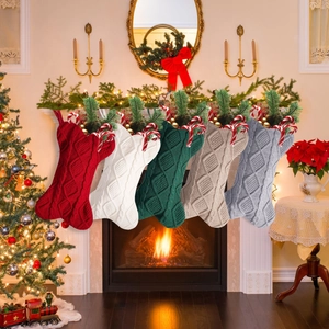 Set of five multi-color cable knit bone-shaped Christmas stockings hanging on a fireplace