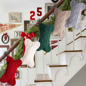 Detailed knit texture of bone-shaped Christmas stockings hanging on stairs railing