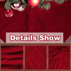 Details einer roten Strick-Weihnachtsbaumdecke mit Rautenmuster und festlicher Schleife