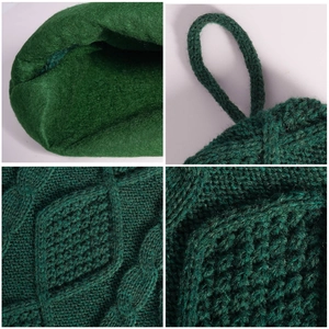 Close-up of emerald green knitted Christmas stocking with diamond texture and hanging loop