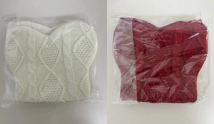 Detail view of red and white cable knit Christmas bone stockings in clear packaging