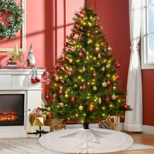 Detail of white chunky knit Christmas tree skirt under decorated tree with warm LED lights