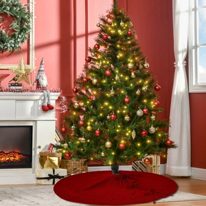 Detail of red cable knit Christmas tree skirt with festive ties near a fireplace