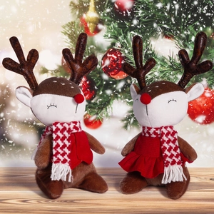 Detail of cute seated Christmas reindeer plush toys with scarves in festive scene