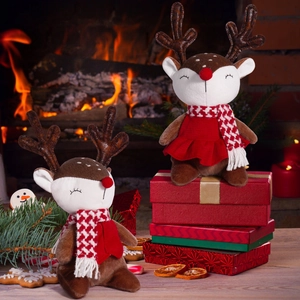 Cute plush Christmas reindeer dolls with red scarves sitting by a festive fireplace