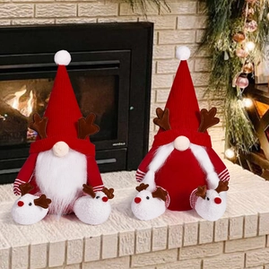 Détail de gnomes de Noël avec bois de renne et bonnets tricotés près de la cheminée