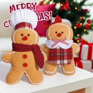 Detail of plush gingerbread couple dolls with festive scarves and chef hat decor
