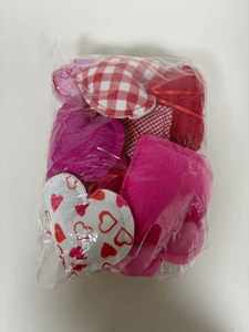 Detailed view of 12 mixed heart fabric ornaments including plaid and solid red patterns