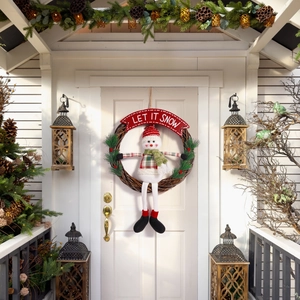 Detail eines Weihnachts-Schneemann-Kranzes mit 'LET IT SNOW' Banner und roten Beeren an der Tür