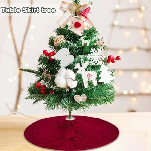 Close-up of red knit Christmas tree skirt with bow ties and wavy woven texture