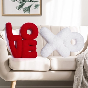 Close-up of red LOVE and white XO alphabet pillows in soft plush textured fabric