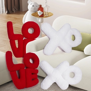 Detail of red LOVE letters and white XO plush cushions made of textured sherpa fabric