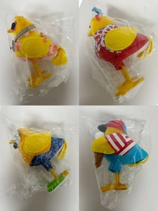 Detail view of four decorative fabric summer birds with floral and striped outfits