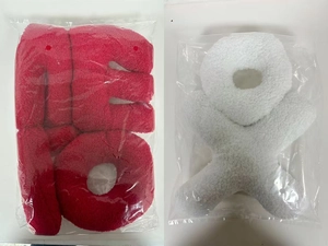 Detail of red FU character and white star plush cushions in protective packaging
