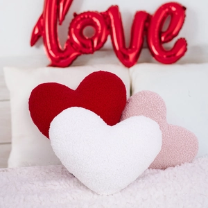 Close-up of heart-shaped pillows in red, white and pink sherpa fleece texture